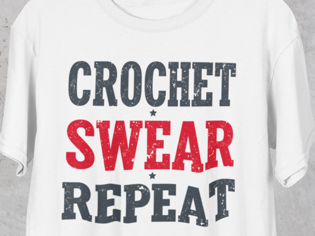 White t-shirt with 'Crochet Swear Repeat' text in black, red, and gray on a plain background.