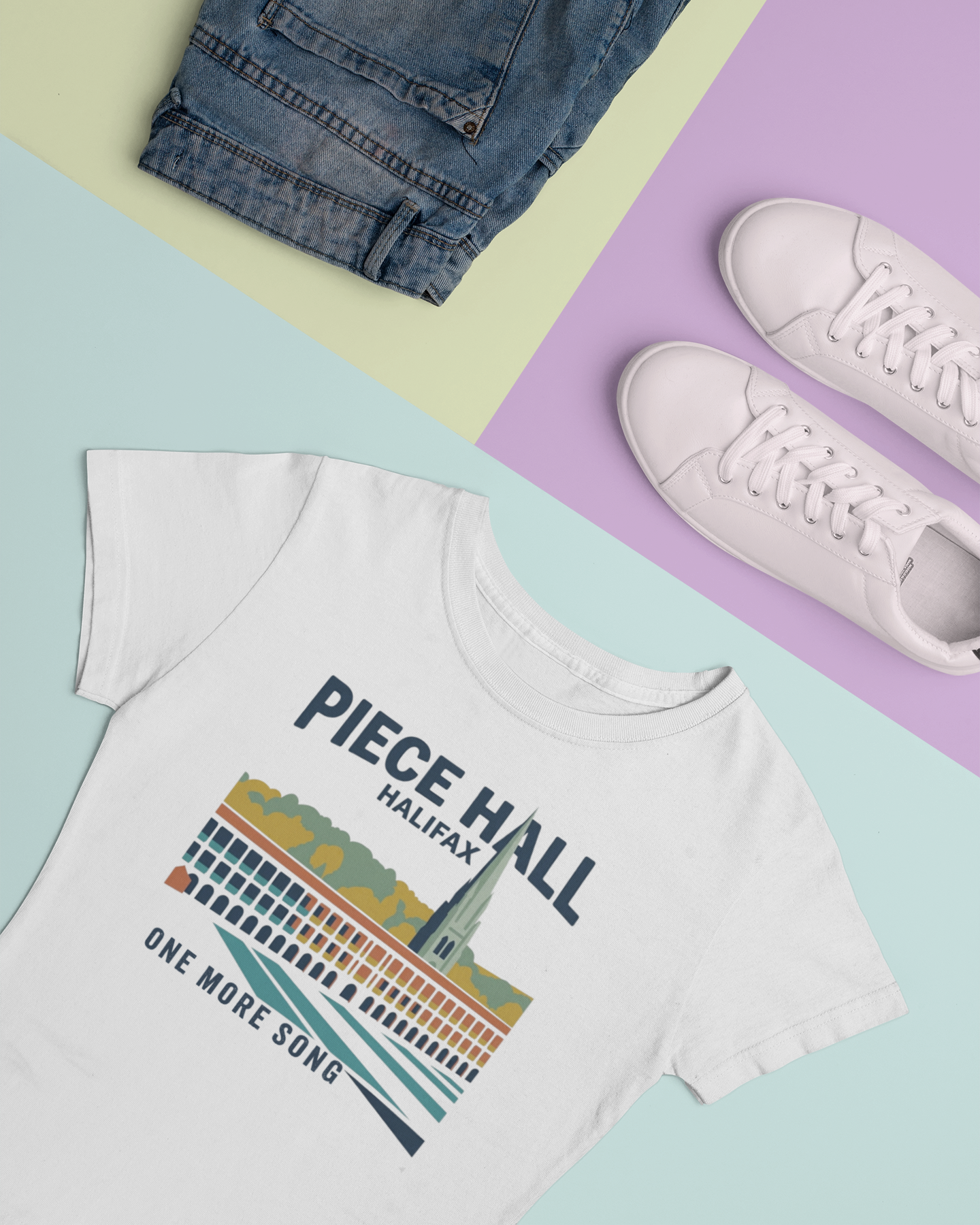 White t-shirt with 'Piece Hall Halifax' design on a colorful background with jeans and sneakers.