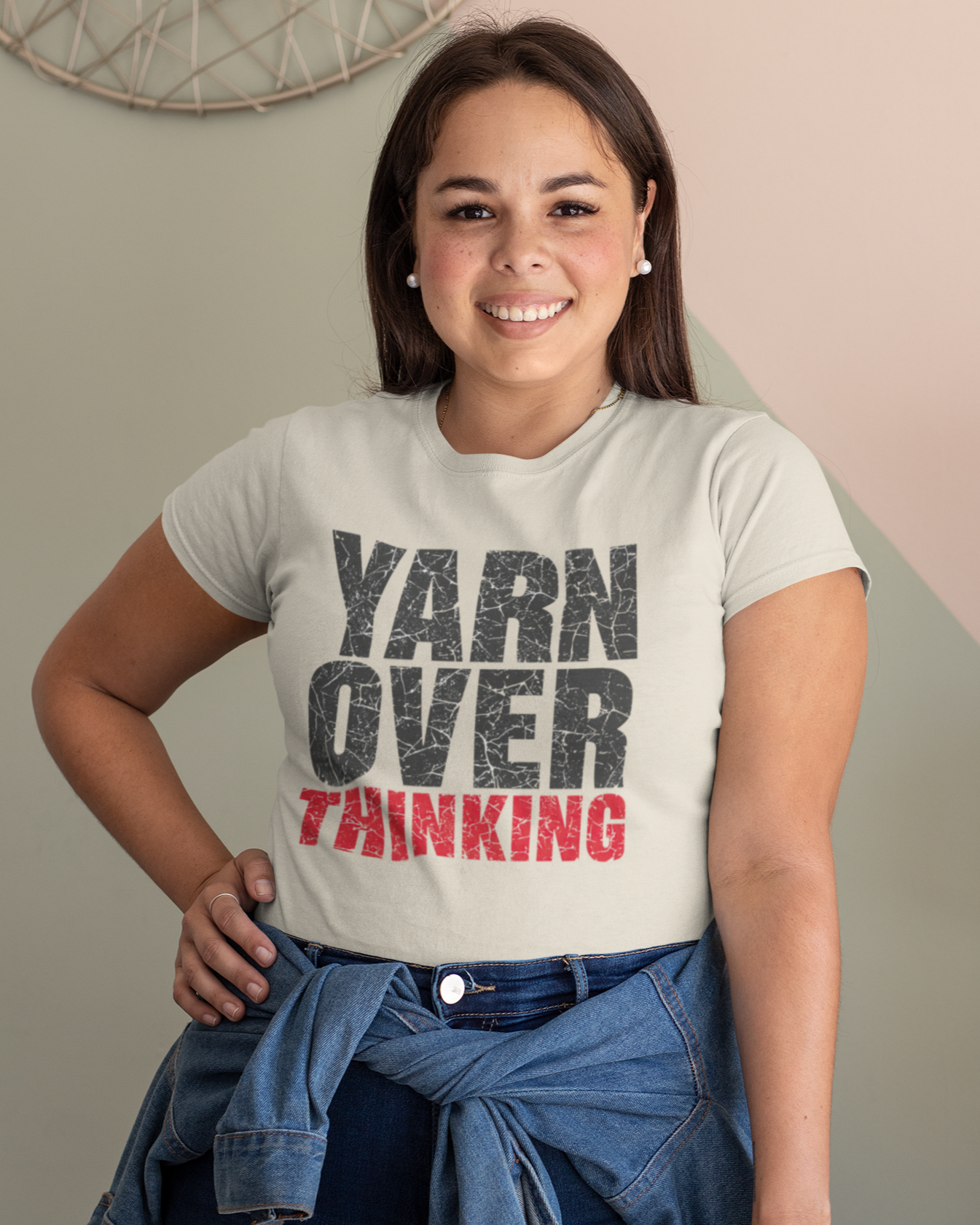 Person wearing a t-shirt with 'YARN OVER THINKING' text, standing against a neutral background.