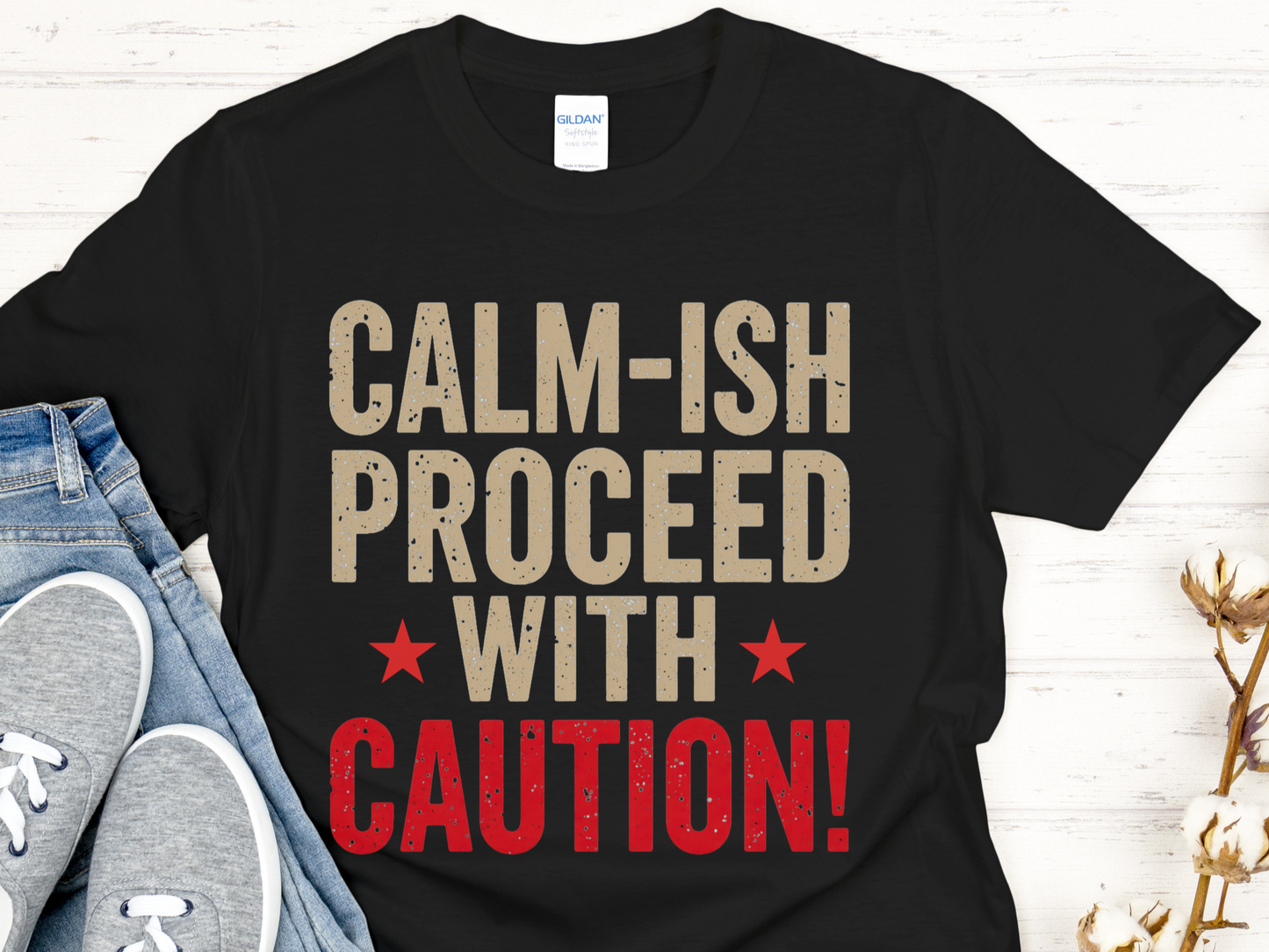 Black t-shirt with 'CALM-ISH PROCEED WITH CAUTION!' text on a white background