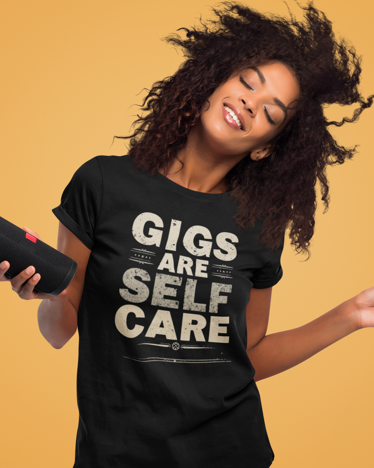 Woman wearing a black t-shirt with 'Gigs are Self Care' text on a yellow background