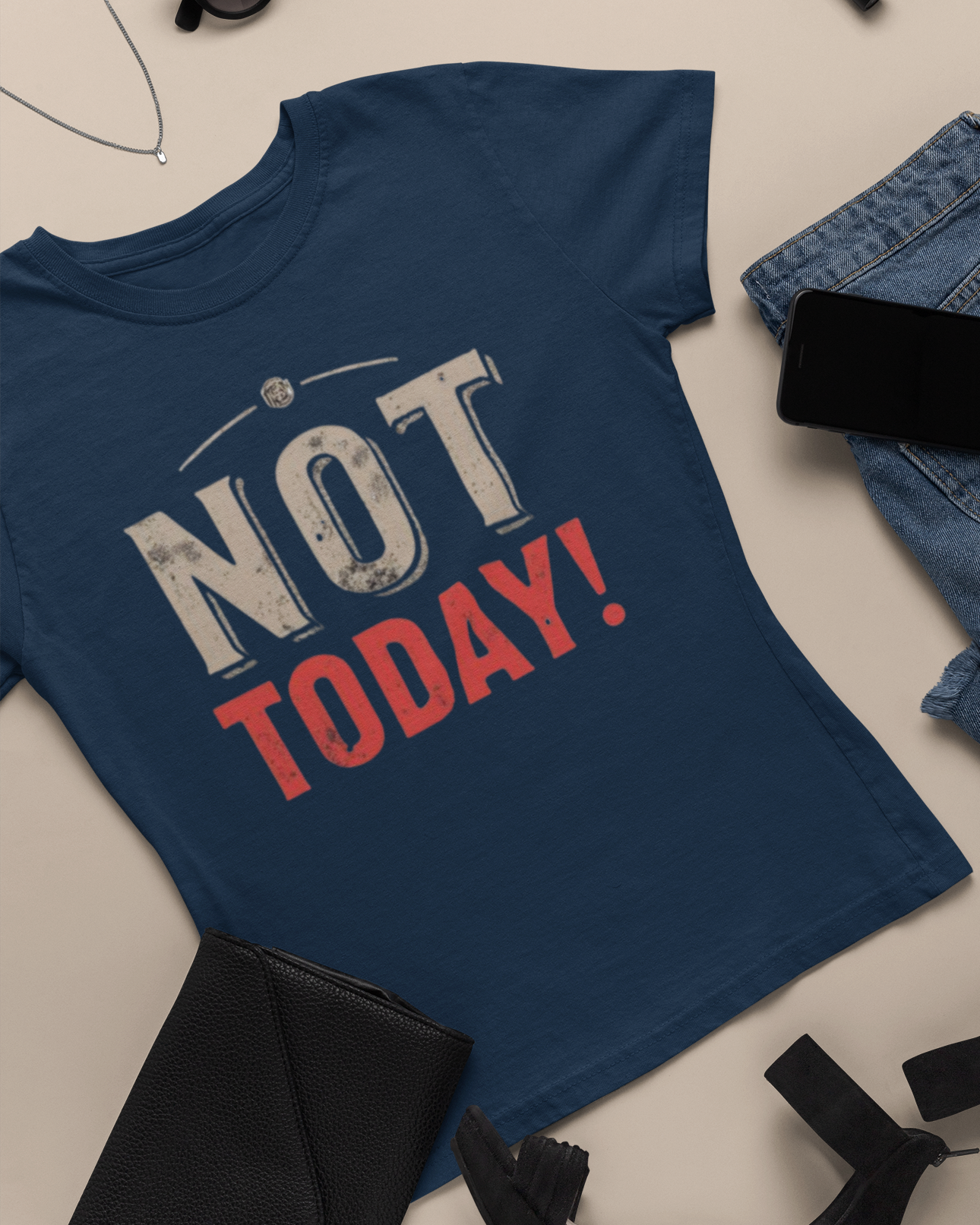 Blue t-shirt with 'NOT TODAY!' text on a beige surface with jeans and shoes.